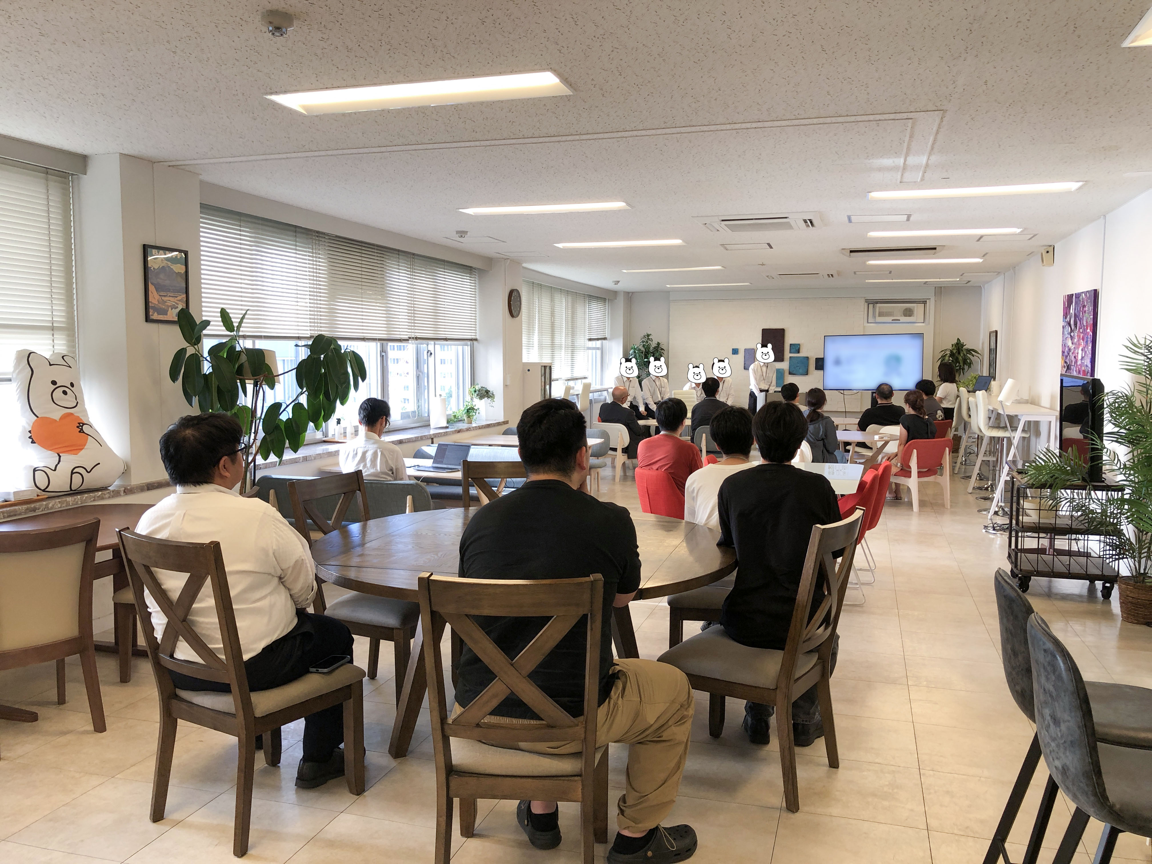 大勢の社員が見守る成果報告会の会場風景