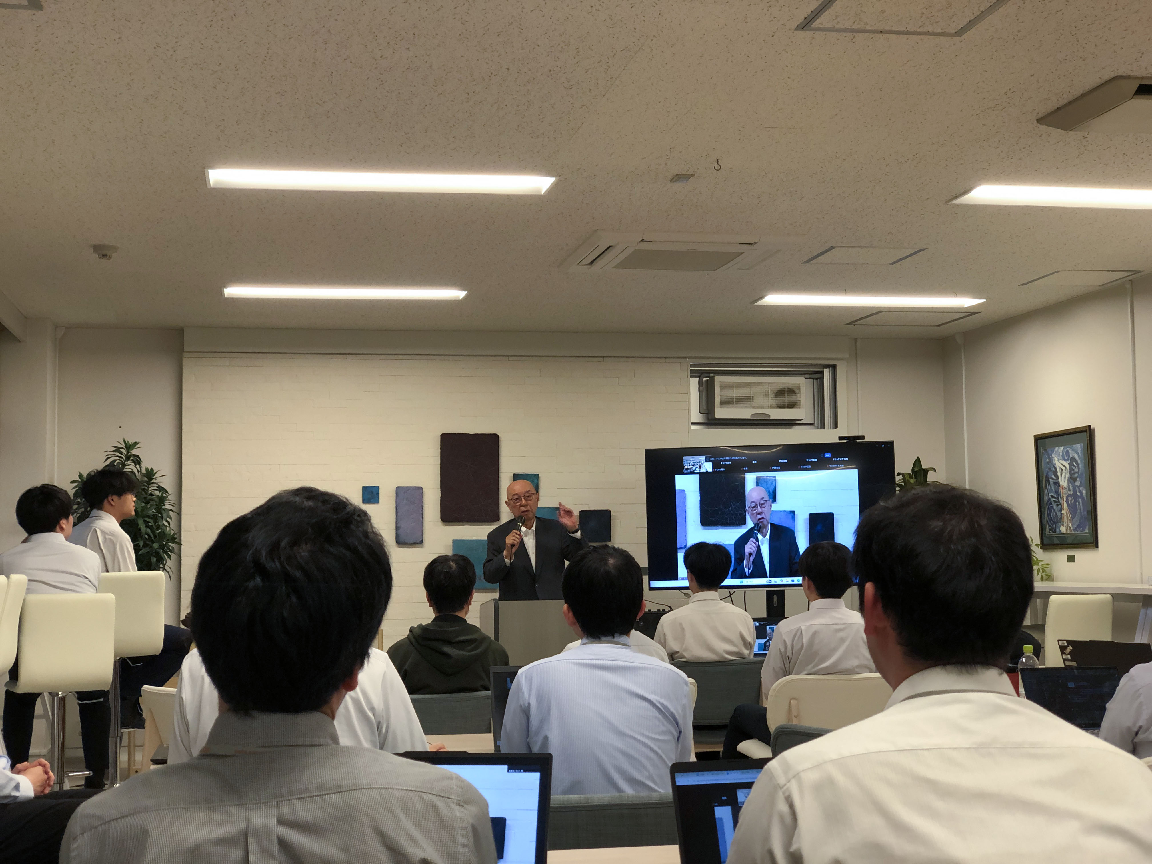 デジックAI研究発表会で開会の挨拶をする代表取締役